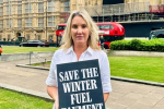 Dame Caroline Dinenage MP holding a sign that states 'Save the Winter Fuel Payment'