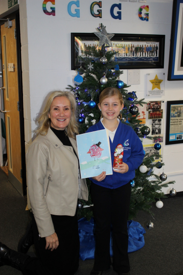 Caroline Dinenage with the winner of her 2024 Christmas card competition, Emelia